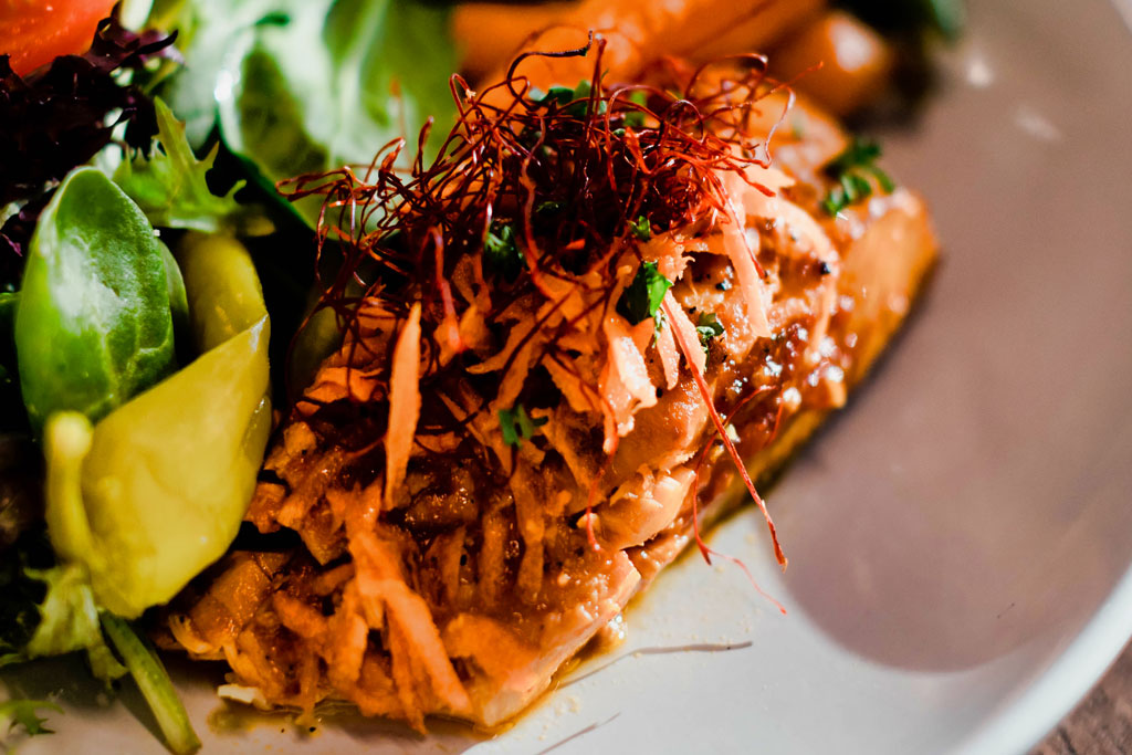 Premium executive lunch featuring mixed field green salad, blackened salmon, roasted vegetables and gourmet sides